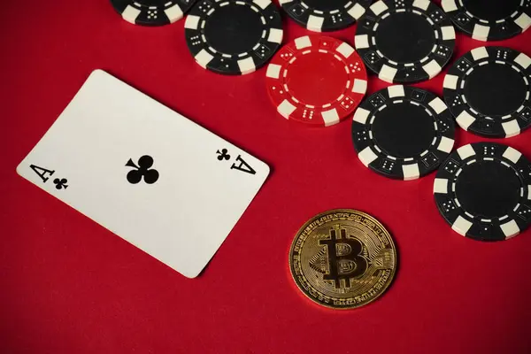 A game scene shows an ace of clubs card next to a bitcoin coin and various poker chips on a vibrant red surface